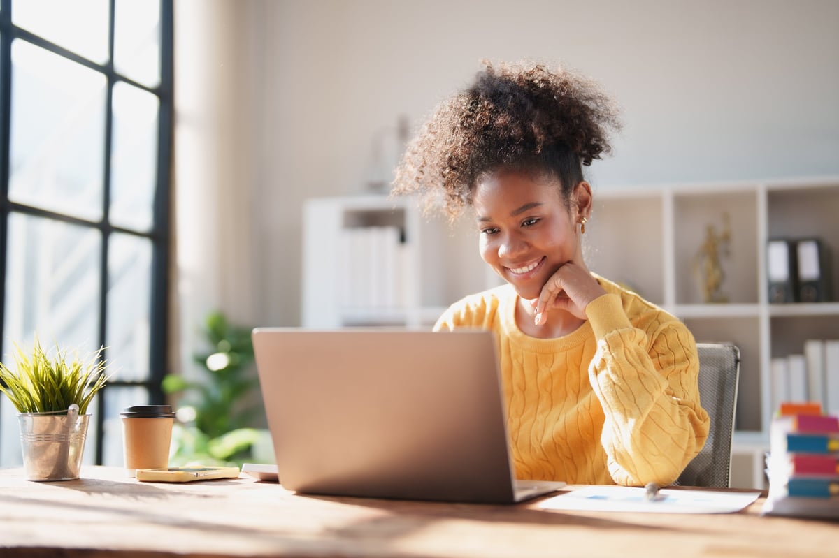 Professional using laptop, smiling at work
